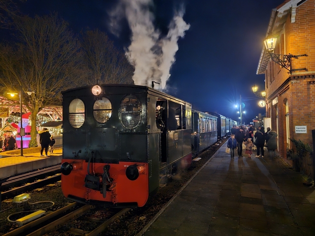 Abb.: Der letzte Nikolauszug ist in Bruchhausen-Vilsen angekommen, Dampf und Licht geben dem Bahnhof eine heimelige Atmosphäre. Im 'Winterschlemmerdorf' ganz links geht es etwas knalliger zu.